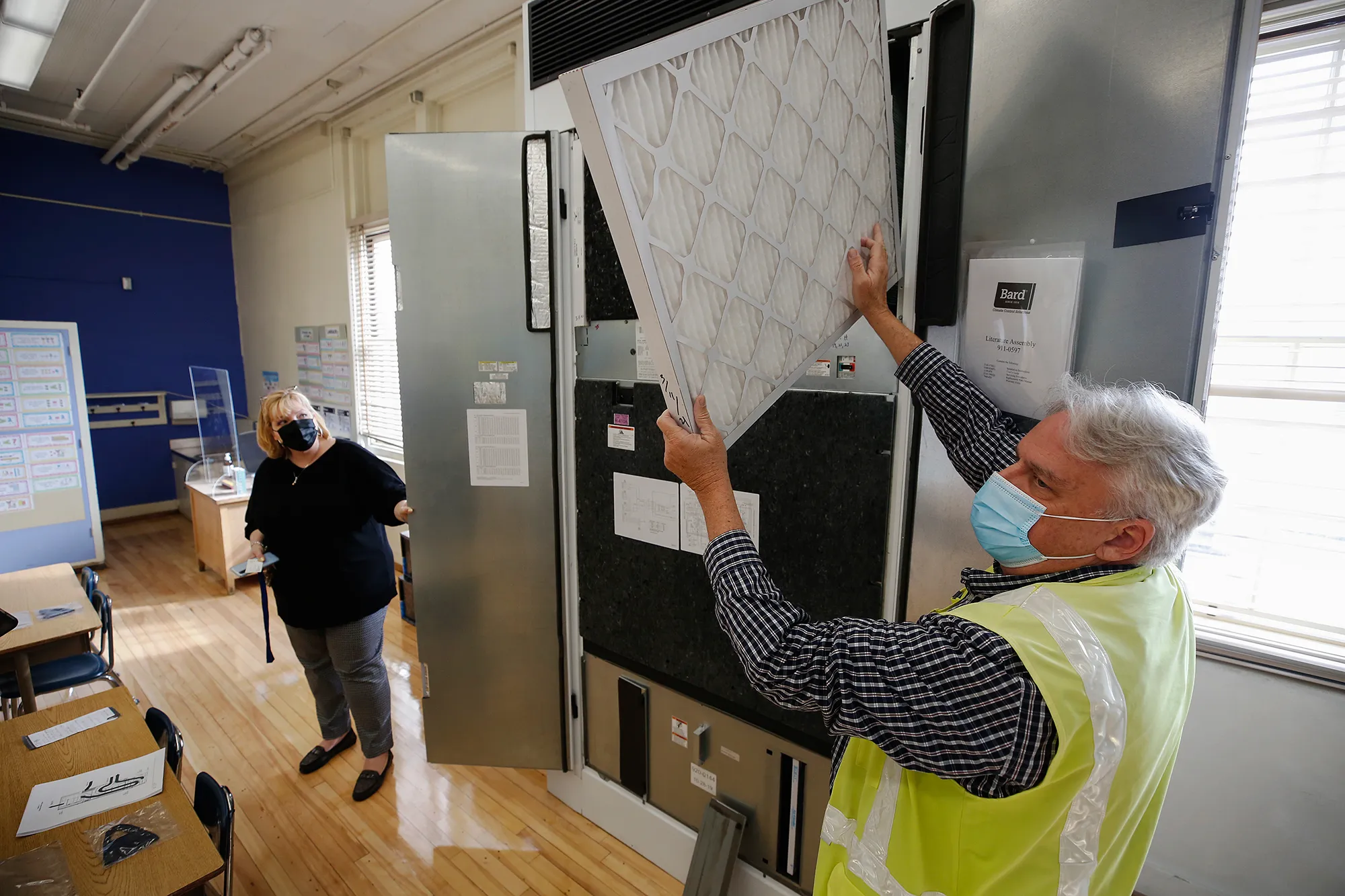 Randy Lemons, senior project manager for construction projects, and Principal Dr. Elizabeth Lehmann show an HVAC unit inside a kindergarten classroom at West Hollywood Elementary School in West Hollywood on March 18, 2021. Photo by Al Seib, Los Angeles Times via Getty Images